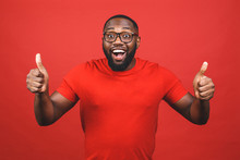 Closeup Portrait Of Happy Young Handsome Man Looking Shocked Surprised Open Mouth Eyes, Isolated On Red Background. Positive Human Emotion Facial Expression Feeling. Thumbs Up.