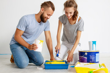 Wall Mural - young happy couple is repairing and painting   wall at home