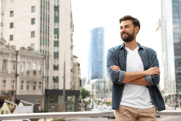 Handsome man in stylish outfit on city street