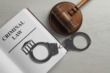 Wall Mural - Judge's gavel, handcuffs and Criminal law book on white wooden background, flat lay