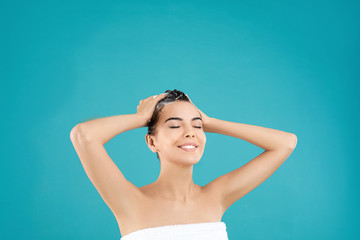 Poster - Beautiful young woman washing hair on light blue background