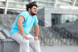 © New Africa - Young overweight man in sportswear resting outdoors