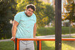 © New Africa - Young overweight man training on sports ground