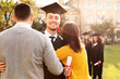© New Africa - Happy student with parents after graduation ceremony outdoors