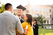 © New Africa - Happy student with parents after graduation ceremony outdoors