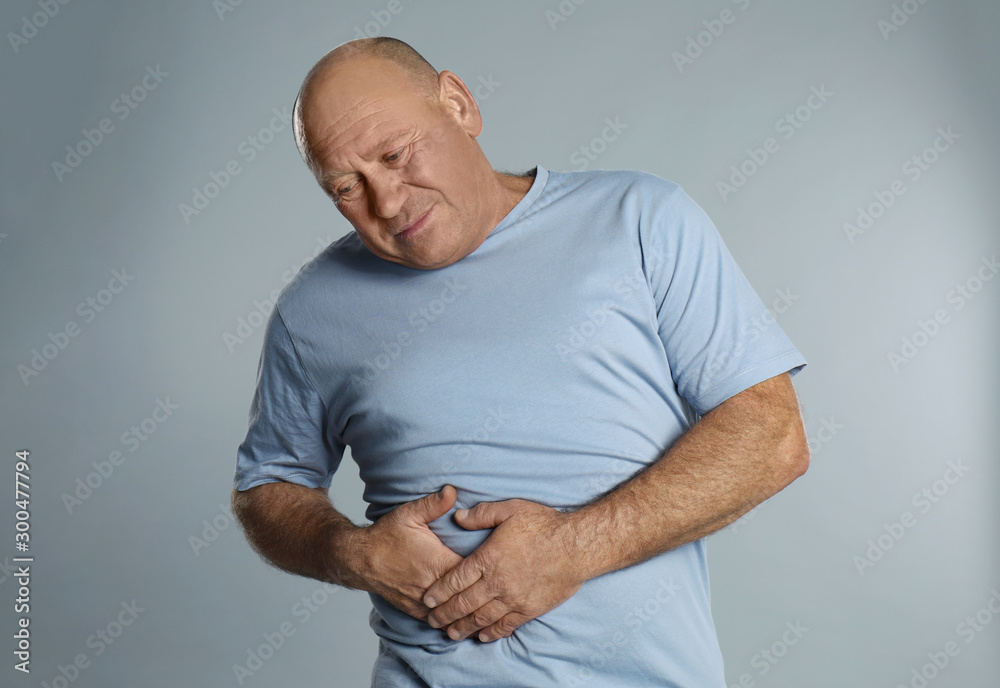 Mature man suffering from liver pain on light grey background - obrazy, fototapety, plakaty 
