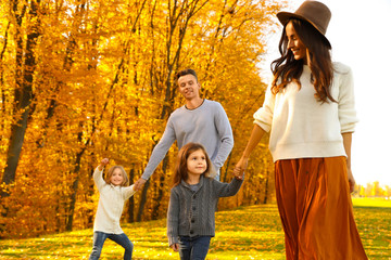 Wall Mural - Happy family with little daughters walking in autumn park