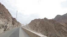 The Car Rides Along A Wild Road Between The Rocks Along Oman. The Car Moves Along The Road, The Camera Removes The Road And The Surrounding Landscapes From The Car