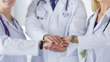 Wall Mural - Doctors and nurses in a medical team stacking hands