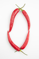 Red hot pepper on a white background in the shape of the letter O. Useful vegetable food and vitamins.