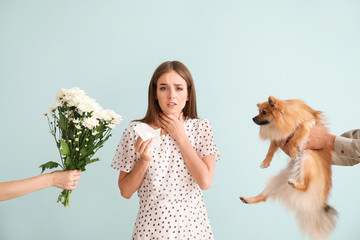 Wall Mural - People giving flowers and dog to young woman suffering from allergy on light background