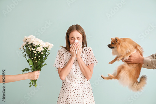 Fotografía People giving flowers and dog to young woman suffering from allergy on light bac