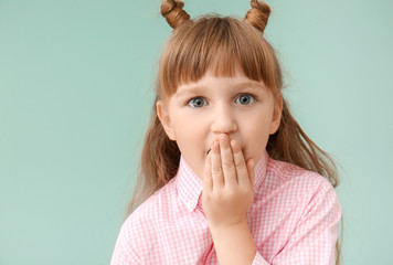 surprised little girl on color background