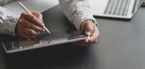 Wall Mural - Cropped shot of successful businessman working on his project with tablet