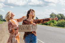Two Beautiful Girls Hitchhiking And Vote With A Sign ANYWHERE On Road. Copy Space.