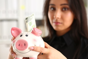 woman hold piggybank in arms