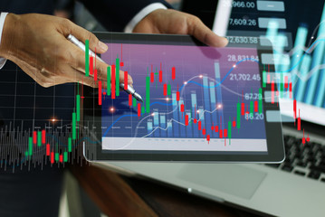 Businessman holding tablet and present financial stock market graph and economic growth chart, Business strategy and planning concept.