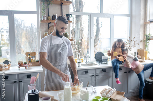 Fotomural Bearded man wearing apron cooking pie for their daughters