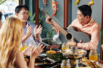 Sticker - Group of Vietnamese people clapping to their friend playing guitar and singing at dinner