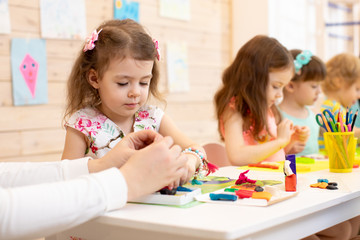 Art and craft activity in kindergarten. Preschool kids hands working in day care center. Group of children engaged in handcrafts