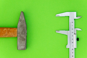 hammer and caliper construction and repair concept, blank space for text on green background