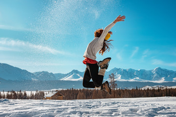 Happy girl jumps with snow winter concept