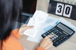 © inews77 - Woman is pressing calculator and calculate cost bill for dealing finance and income.