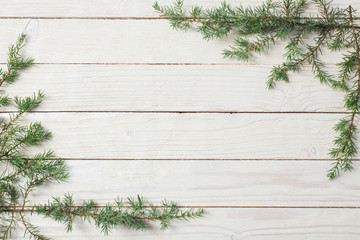 Wall Mural - juniper branches on a white wooden background. Christmas and New