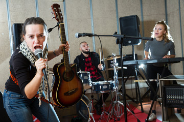 excited girl rock singer with guitar during rehearsal