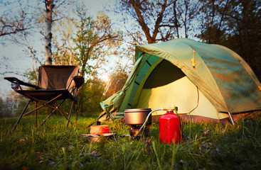 camping in the woods with a backpack and a tent on the banks of the river .