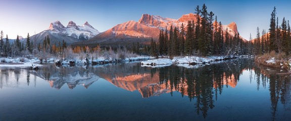 Wall Mural - sunrise of the three sisters and the bow river from canmore near banff national park. first snow in 