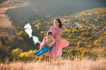 Wall Mural - mother whirling with son in field