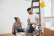 © cherryandbees - young couple decorating and painting indoor walls in their home