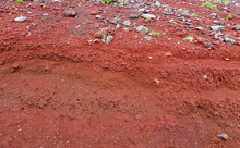A Cut Of Soil With Rocks And Red Soil
