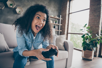 Poster - Closeup photo of pretty dark skin wavy lady hold gamepad console joystick addicted gamer worried excited sitting comfy couch casual denim outfit living room indoors