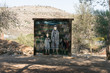 A stand with a picture of ancient settlers with holes for faces for photographing at the entrance to the archaeological site of Tel Shilo in Samaria region in Benjamin district, Israel