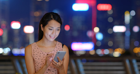 Wall Mural - Woman use of smart phone at sunset time