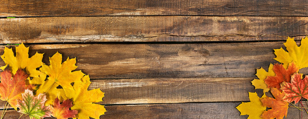 Wall Mural - autumn maple leaves on top view wooden table. horizontal frame with two bottom corner.