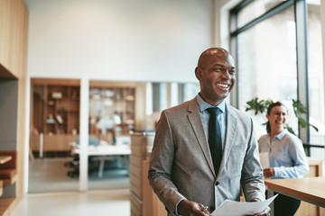 african american businessman laughing while walking through a mo