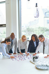 Smiling businesspeople solving a puzzle on an office table