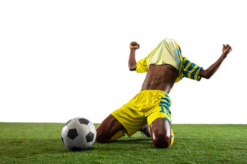 Wall Mural - Professional african-american football or soccer player of yellow team in motion isolated on white studio background. Fit man in action, excitement, emotional moment. Concept of movement at gameplay.