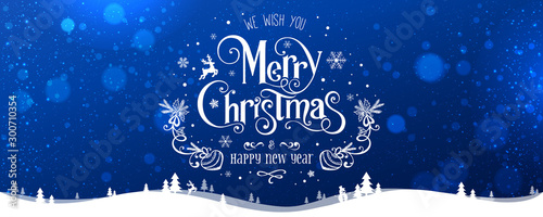 Fotografía Merry Christmas and New Year text on blue background with winter landscape with snowflakes, light, stars