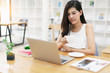 © Somkiat - Portrait of a young business woman using laptop computer while working. Young asian business woman working with laptop in coffee shop cafe.