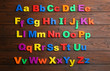 Colorful magnetic letters on wooden background, flat lay. Alphabetical order
