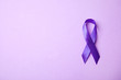 Purple ribbon on lilac background, top view with space for text. Domestic violence awareness