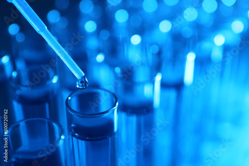 Fotografía Dripping reagent into test tube with liquid sample, closeup