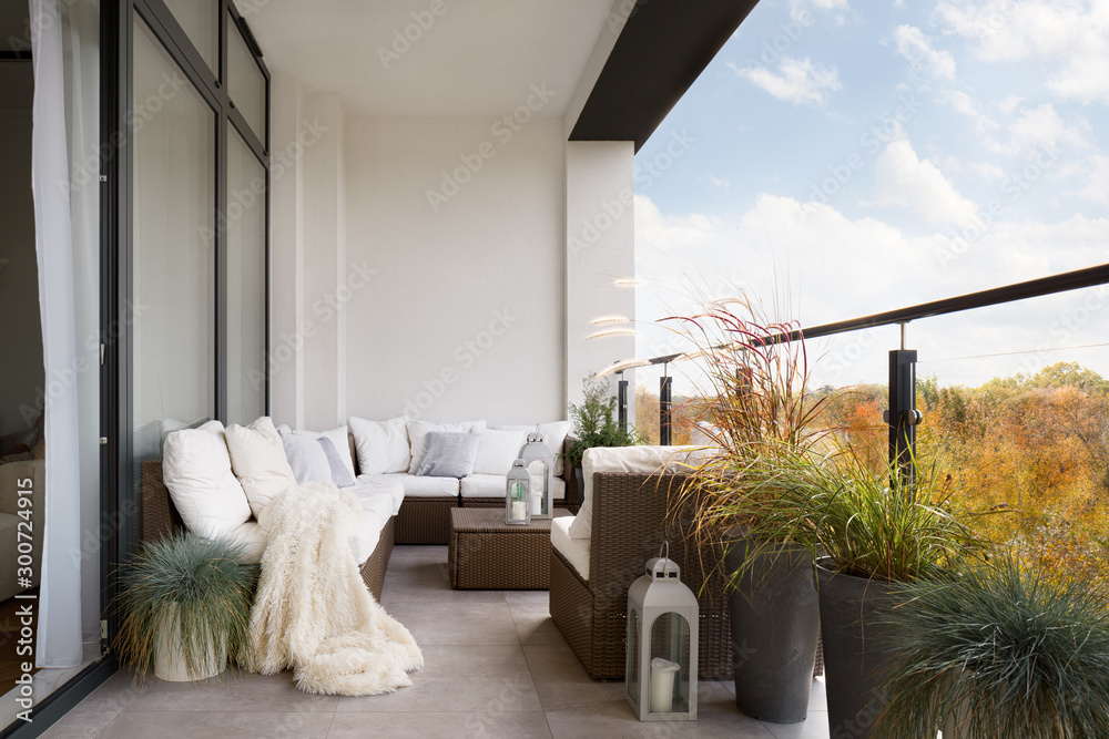 Elegant decorated balcony with rattan outdoor furniture, bright pillows and plants - obrazy, fototapety, plakaty 
