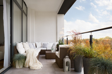 Wall Mural - elegant decorated balcony with rattan outdoor furniture, bright pillows and plants