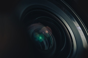 Aufkleber - Beautiful camera lens with geen and pink light of glass on a black background. Macro photography view.