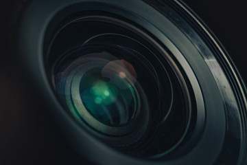 Aufkleber - Beautiful camera lens with geen and pink light of glass on a black background. Macro photography view.